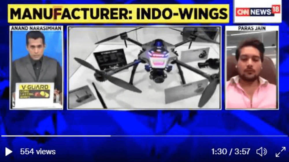 three frame of media in one frame one man is sitting in black suit in middle
                    frame black coloured drone in third frame a man is sitting in pink shirt