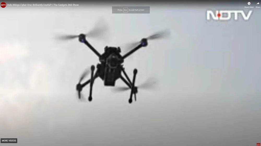 black drone is flying in the sky